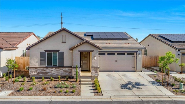 view of front of house featuring solar panels, concrete driveway, fence, and stucco siding