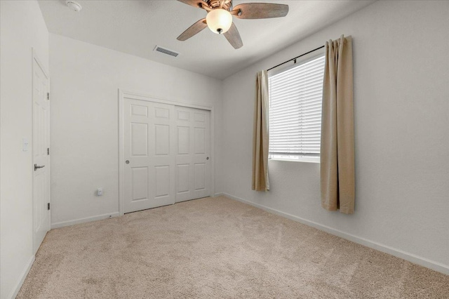 unfurnished bedroom featuring carpet, baseboards, a closet, and ceiling fan