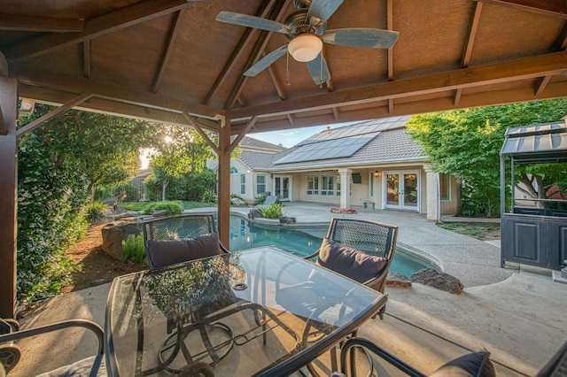 view of patio with french doors, outdoor dining area, ceiling fan, an outdoor pool, and a gazebo