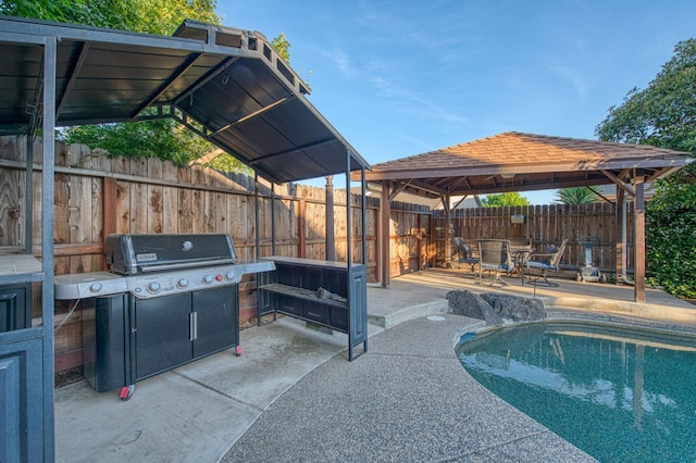 view of pool with a gazebo, a patio, grilling area, and a fenced backyard