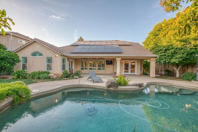 view of pool with french doors, a patio, and fence