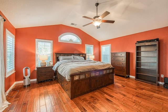 bedroom with wood-type flooring, vaulted ceiling, baseboards, and a ceiling fan