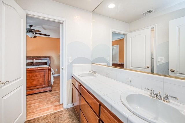 ensuite bathroom featuring a ceiling fan, double vanity, baseboards, and recessed lighting
