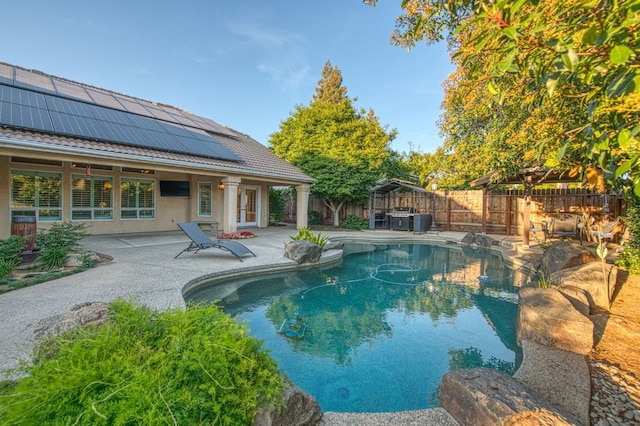 view of pool with a hot tub, a fenced backyard, and a patio area