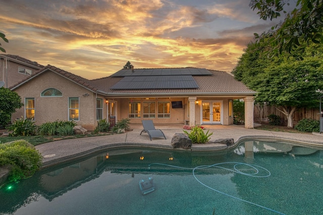 view of swimming pool with french doors, a patio area, and fence