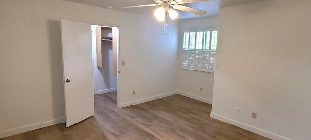 spare room with ceiling fan, baseboards, and wood finished floors