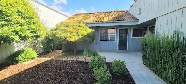 exterior space with fence and a tile roof