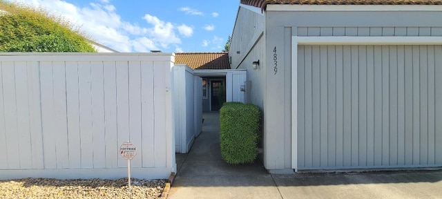 view of side of property with a tile roof and fence