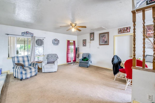 sitting room with a ceiling fan, carpet, a textured ceiling, and baseboards