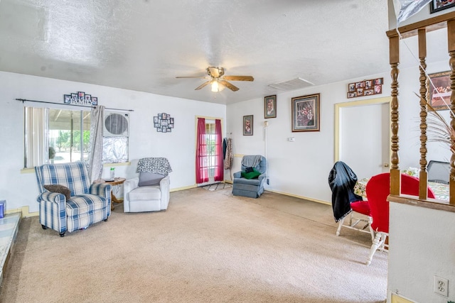 living area featuring ceiling fan, carpet floors, a textured ceiling, and baseboards