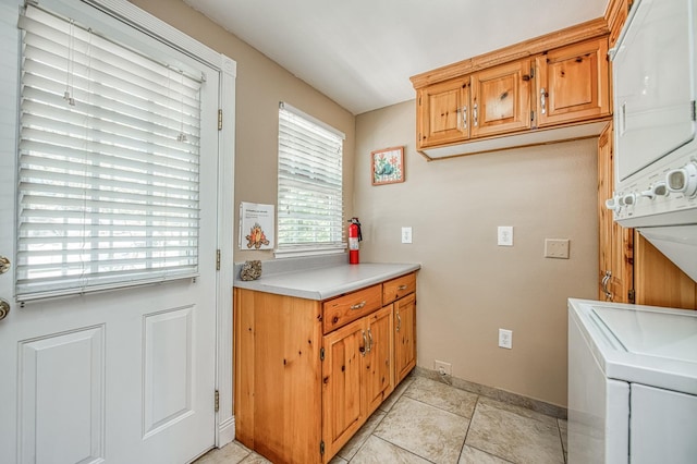 41533 Indian Rock Rd, Shaver Lake, CA 93664 - laundry area with stacked washer / dryer, cabinet space, baseboards, and light tile patterned floors