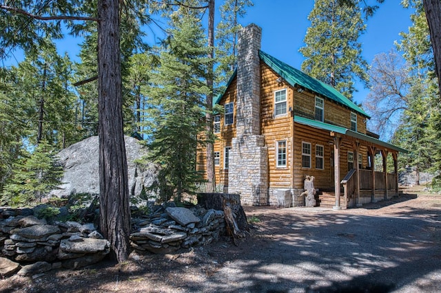 41533 Indian Rock Rd, Shaver Lake, CA 93664 - view of side of home featuring faux log siding, a chimney, and a porch