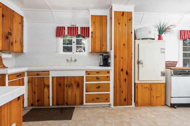 58374 Huntington Lake Rd Unit 12, Lakeshore, CA 93634 - kitchen featuring dishwasher, brown cabinetry, decorative backsplash, a sink, and tile counters