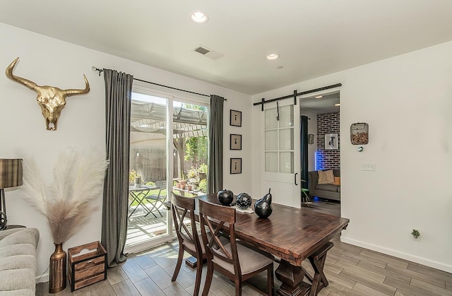 7005 N Astoria Ave, Fresno, CA 93722 - dining space with a barn door, wood finish floors, baseboards, and recessed lighting