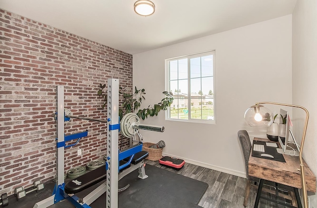 7005 N Astoria Ave, Fresno, CA 93722 - exercise room featuring wood finished floors, brick wall, and baseboards