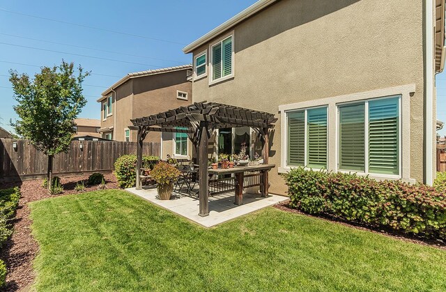 7005 N Astoria Ave, Fresno, CA 93722 - back of property with a pergola, a patio area, and stucco siding