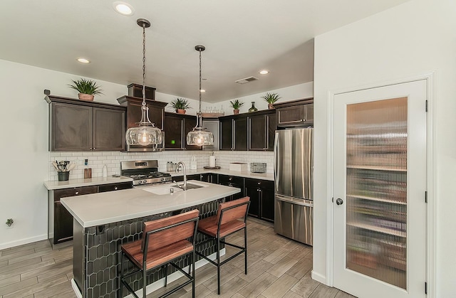7005 N Astoria Ave, Fresno, CA 93722 - kitchen featuring stainless steel appliances, a sink, wood finish floors, light countertops, and recessed lighting