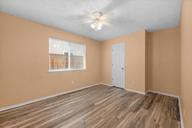 6380 N Cleo, Fresno, CA 93722 - empty room with a textured ceiling, wood finished floors, ceiling fan, and baseboards