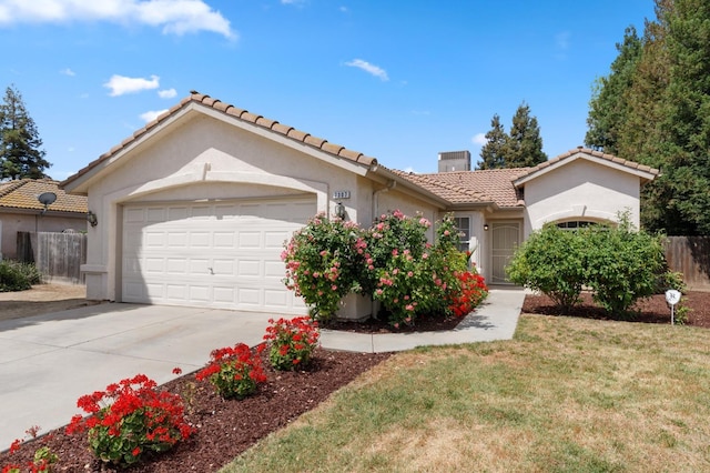 7307 N Lola Ave, Fresno, CA 93722 - view of front of property with a chimney, a tiled roof, stucco siding, an attached garage, and concrete driveway