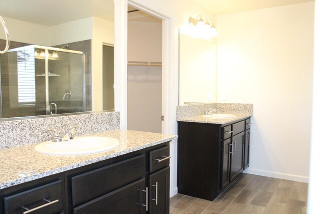 2158 W Ambassador Way, Hanford, CA 93230 - full bath with a shower stall, wood finished floors, two vanities, a walk in closet, and baseboards