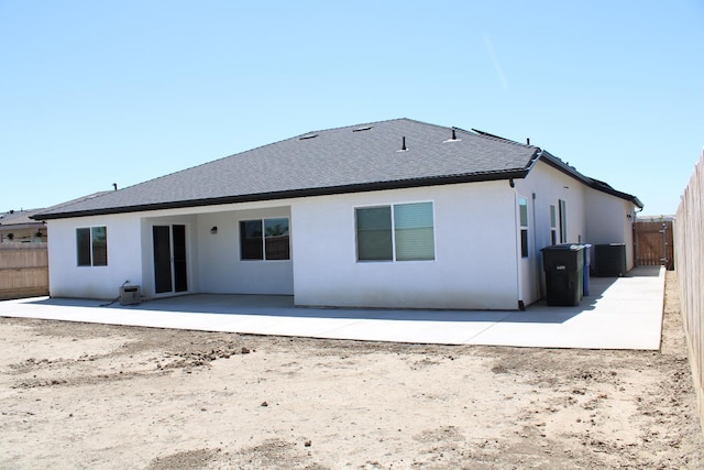 2158 W Ambassador Way, Hanford, CA 93230 - back of house featuring a patio area, fence, roof with shingles, stucco siding, and central AC unit