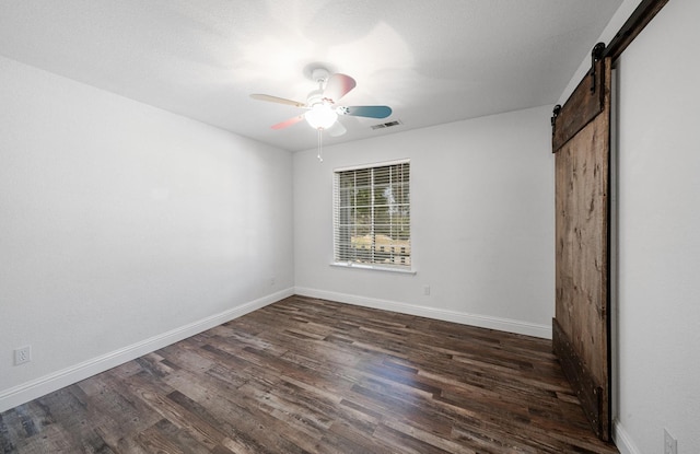 43480 Cave Stone Ct, Coarsegold, CA 93614 - unfurnished bedroom with a barn door, dark wood-style floors, and baseboards