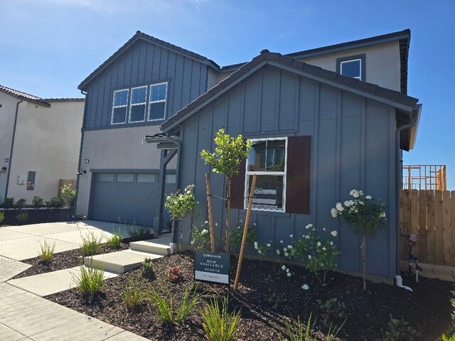 2875 E Colina Dr, Fresno, CA 93730 - view of front of home featuring board and batten siding, concrete driveway, and an attached garage