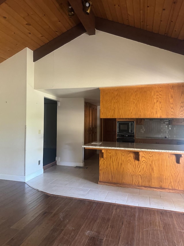 399 E Richmond Ave, Fresno, CA 93720 - kitchen featuring built in microwave, beamed ceiling, light wood finished floors, high vaulted ceiling, and a kitchen breakfast bar