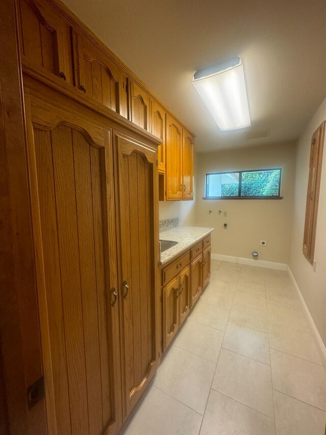 399 E Richmond Ave, Fresno, CA 93720 - laundry room featuring cabinet space, hookup for a washing machine, light tile patterned floors, and baseboards