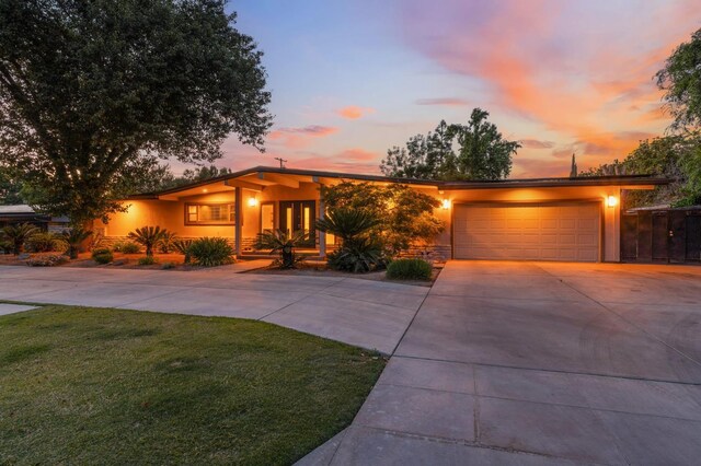 1478 W Dovewood Ln, Fresno, CA 93711 - mid-century inspired home featuring an attached garage, driveway, stucco siding, and a lawn