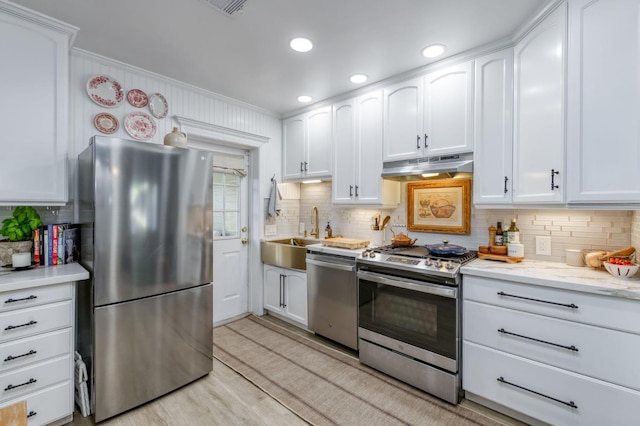 3519 N Van Ness Blvd, Fresno, CA 93704 - kitchen featuring appliances with stainless steel finishes, under cabinet range hood, a sink, backsplash, and ornamental molding