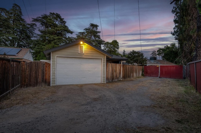 3519 N Van Ness Blvd, Fresno, CA 93704 - garage at dusk with driveway, a garage, and fence