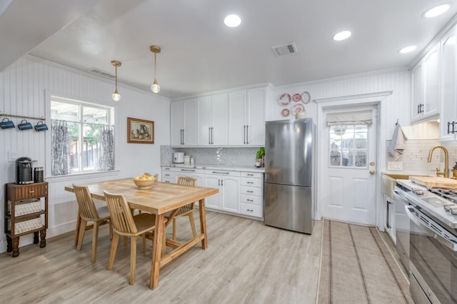 3519 N Van Ness Blvd, Fresno, CA 93704 - kitchen with appliances with stainless steel finishes, ornamental molding, light countertops, tasteful backsplash, and light wood finished floors