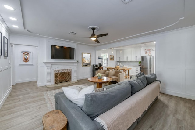 3519 N Van Ness Blvd, Fresno, CA 93704 - living area featuring a decorative wall, light wood-style flooring, ceiling fan, a fireplace with flush hearth, and recessed lighting
