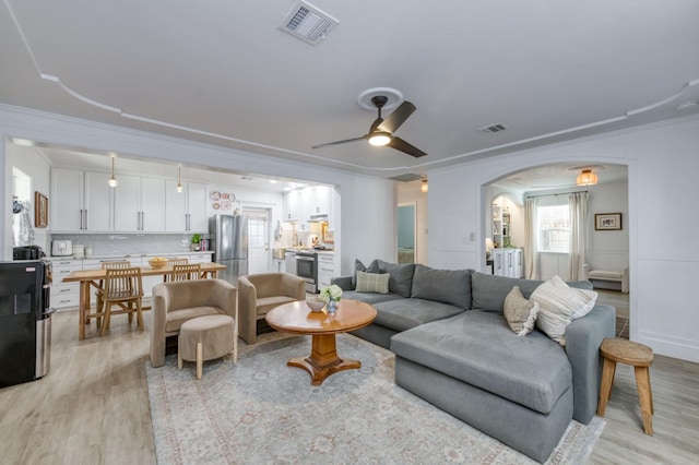 3519 N Van Ness Blvd, Fresno, CA 93704 - living room featuring light wood-style floors, ornamental molding, arched walkways, and a ceiling fan
