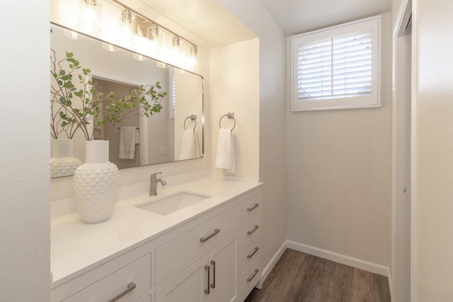 bathroom featuring wood finished floors, vanity, and baseboards