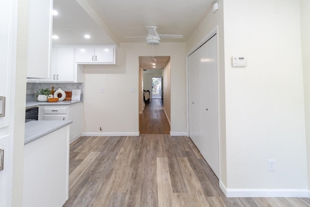 5455 N Marty Ave Unit 132, Fresno, CA 93711 - kitchen featuring white cabinetry, light countertops, light wood-style flooring, tasteful backsplash, and baseboards