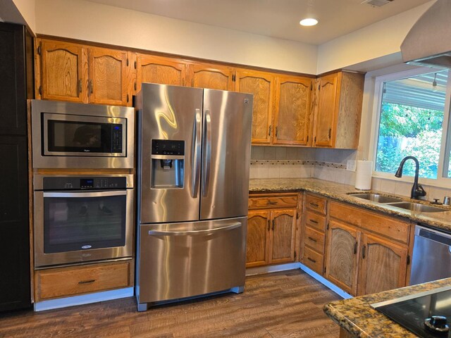 1489 Celeste Ave, Clovis, CA 93611 - kitchen featuring appliances with stainless steel finishes, a sink, brown cabinets, dark wood finished floors, and recessed lighting