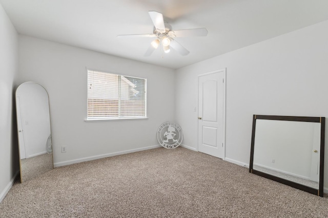 spare room featuring carpet, a ceiling fan, and baseboards