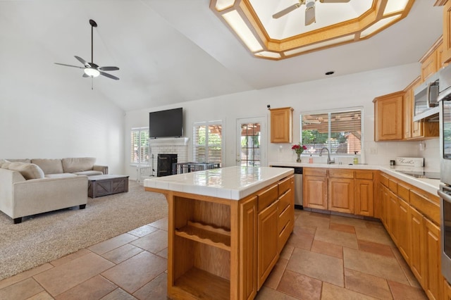 kitchen with a ceiling fan, high vaulted ceiling, stainless steel appliances, tile countertops, and open shelves