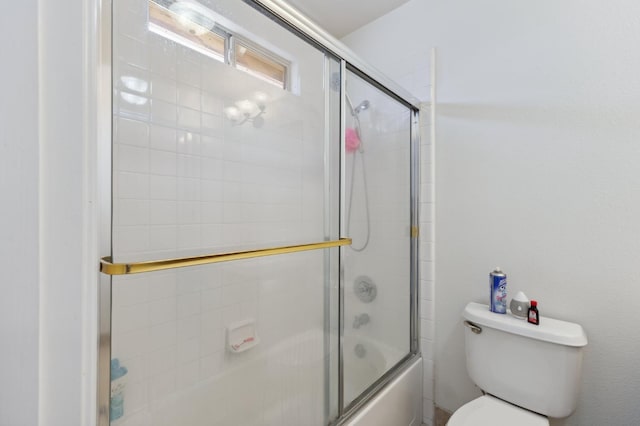 full bath featuring combined bath / shower with glass door and toilet