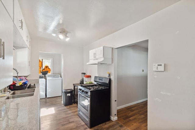 2140 E Floradora Ave, Fresno, CA 93703 - kitchen featuring gas range, under cabinet range hood, separate washer and dryer, and wood finished floors