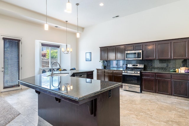 5279 N Ensanada Ave, Fresno, CA 93723 - kitchen featuring stainless steel appliances, a sink, tasteful backsplash, a chandelier, and dark brown cabinetry