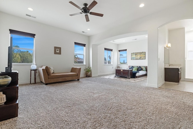 5279 N Ensanada Ave, Fresno, CA 93723 - living room with arched walkways, light colored carpet, a ceiling fan, recessed lighting, and baseboards