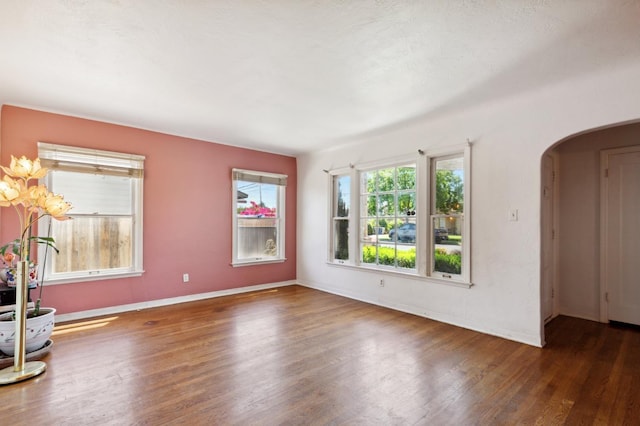 2020 N Fruit Ave, Fresno, CA 93705 - unfurnished room with arched walkways, wood finished floors, and baseboards