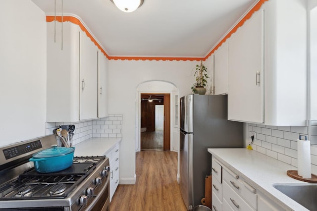 2020 N Fruit Ave, Fresno, CA 93705 - kitchen with appliances with stainless steel finishes, light countertops, white cabinetry, and backsplash