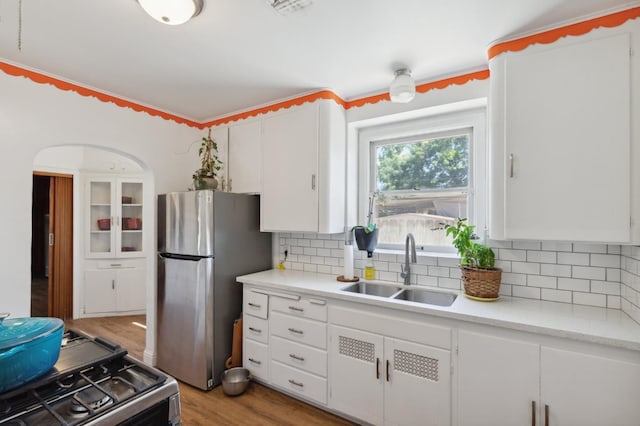 2020 N Fruit Ave, Fresno, CA 93705 - kitchen with freestanding refrigerator, a sink, gas range oven, white cabinets, and backsplash