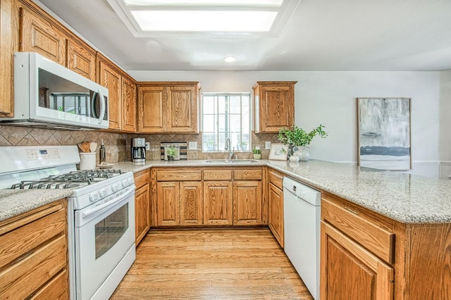 198 Decatur Ave, Clovis, CA 93611 - kitchen featuring white appliances, a sink, a peninsula, light wood-type flooring, and brown cabinetry