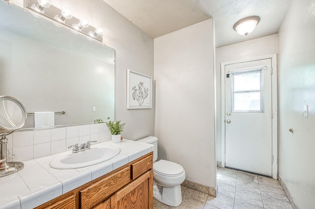 198 Decatur Ave, Clovis, CA 93611 - bathroom featuring toilet, backsplash, tile patterned flooring, vanity, and baseboards