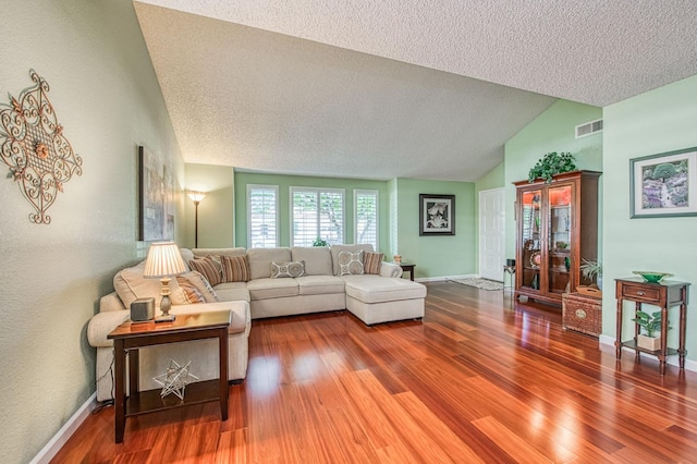 6365 N Barcus Ave, Fresno, CA 93722 - living room with wood finished floors, lofted ceiling, a textured ceiling, and baseboards